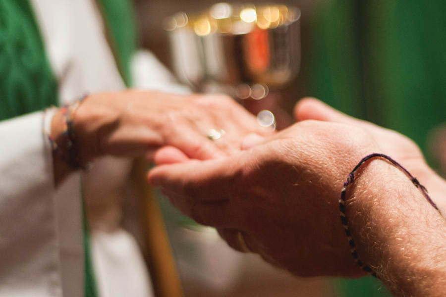 A pair of hands serving Communion