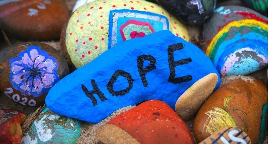 Painted rock with the word "Hope" on top of a pile of painted rocks