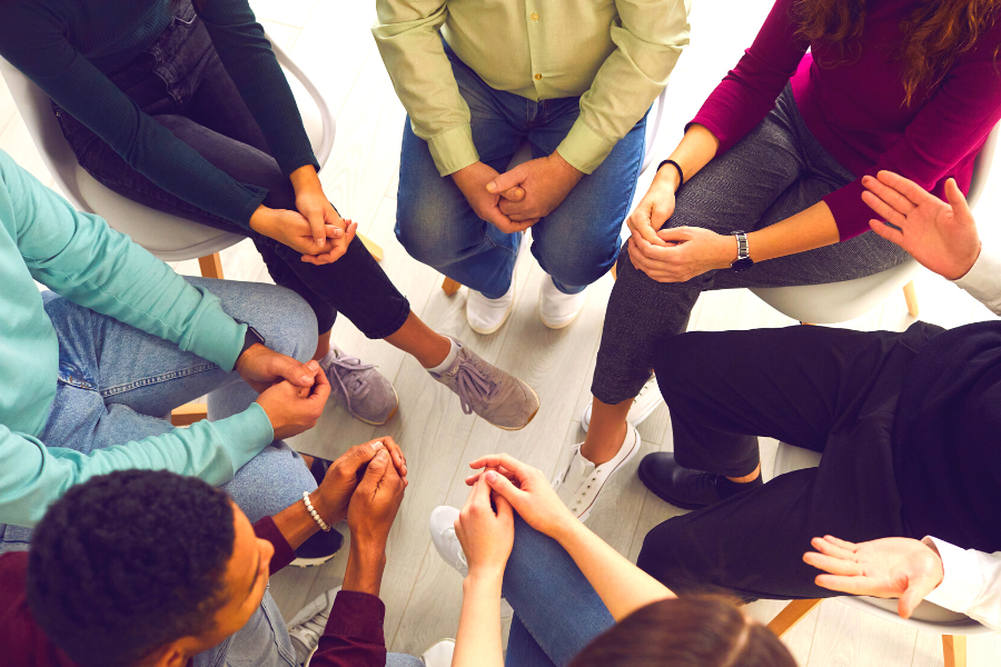 A stock image of a group of people conversing in a circle