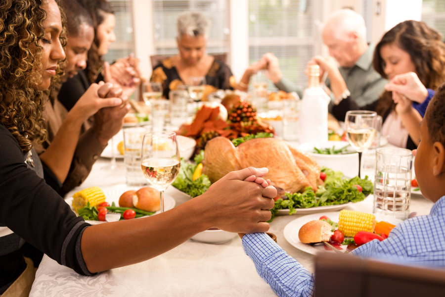 Stock image of a family praying over Thanksgiving dinner